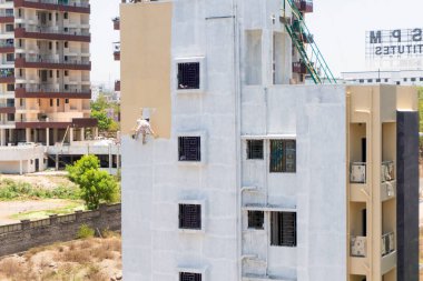 Endüstriyel dağcı duvarları boyarken ipte sallanıyor 