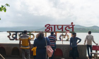 people near sign of Pune ki Chaupati, Khadakwasla Dam, Pune, India clipart