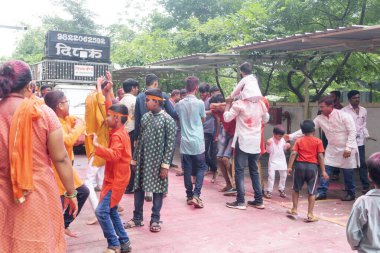 PUNE, MAHARASHTRA, INDIA - 8 EYLÜL 2022: Kimliği belirlenemeyen inançlı insanlar, su kaynaklarının yakınına dalmadan önce Hindu tanrısı Ganesha 'ya dua ediyorlar (Ganesh Chaturthi), yıllık festival