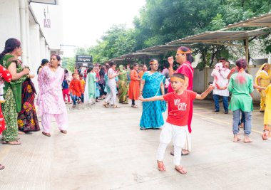 PUNE, MAHARASHTRA, INDIA - 8 EYLÜL 2022: Kimliği belirlenemeyen inançlı insanlar, su kaynaklarının yakınına dalmadan önce Hindu tanrısı Ganesha 'ya dua ediyorlar (Ganesh Chaturthi), yıllık festival