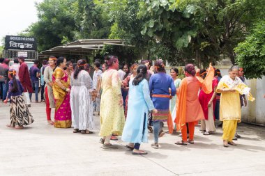 PUNE, MAHARASHTRA, INDIA - 8 EYLÜL 2022: Kimliği belirlenemeyen inançlı insanlar, su kaynaklarının yakınına dalmadan önce Hindu tanrısı Ganesha 'ya dua ediyorlar (Ganesh Chaturthi), yıllık festival