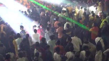 Konserde neon ışıkların ve dans eden insanların gece görüşü