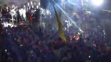 Konserde neon ışıkların ve dans eden insanların gece görüşü