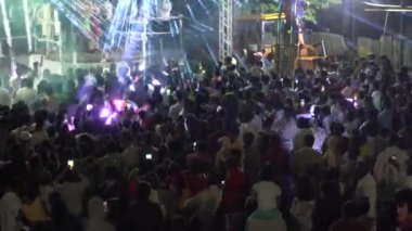 Konserde neon ışıkların ve dans eden insanların gece görüşü