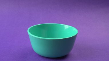 Mor zemin üzerinde yeşil boş seramik kasenin yakın plan görüntüsü.                   