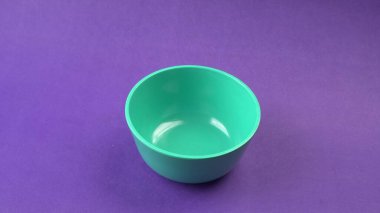 Mor zemin üzerinde yeşil boş seramik kasenin yakın plan görüntüsü.                   