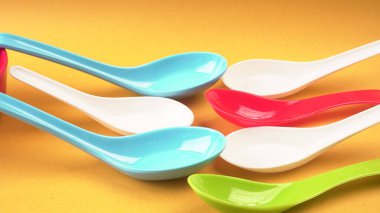 Sarı arka planda mutfak aletleri için renkli kaşıklar..           