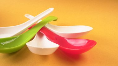 Sarı arka planda mutfak aletleri için renkli kaşıklar..           