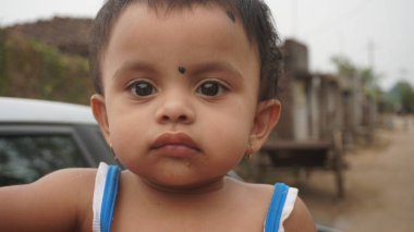 AMRAVATI, MAHARASHTRA, INDIA 12 Aralık 2020: Köydeki evin önünde kimliği belirlenemeyen mutlu Hintli kırsal insanların portresi.