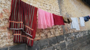 Elbiseler eski caddede ipte kuruyor.  