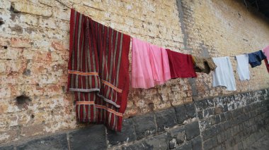 Elbiseler eski caddede ipte kuruyor.  
