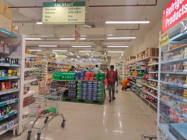 Pune, Maharashtra, Hindistan - 13 Ocak 2025; çok çeşitli gıda ürünleriyle dolu hareketli bir market koridoru. Süpermarketteki raflar satılmak üzere renkli paketlerle dolu..