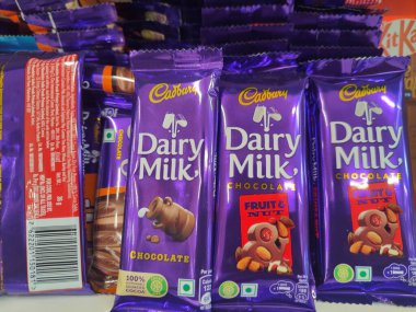 Pune, Maharashtra, Hindistan - 13 Ocak 2025; çok çeşitli gıda ürünleriyle dolu hareketli bir market koridoru. Süpermarketteki raflar satılmak üzere renkli paketlerle dolu..