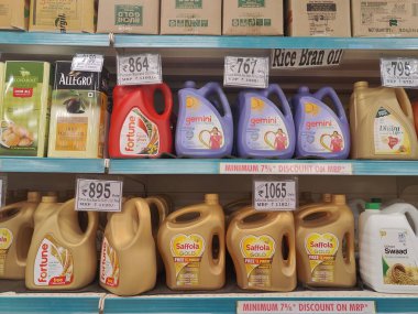 Pune, Maharashtra, Hindistan - 13 Ocak 2025; çok çeşitli gıda ürünleriyle dolu hareketli bir market koridoru. Süpermarketteki raflar satılmak üzere renkli paketlerle dolu..