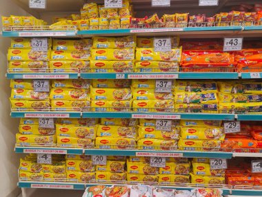 Pune, Maharashtra, Hindistan - 13 Ocak 2025; çok çeşitli gıda ürünleriyle dolu hareketli bir market koridoru. Süpermarketteki raflar satılmak üzere renkli paketlerle dolu..