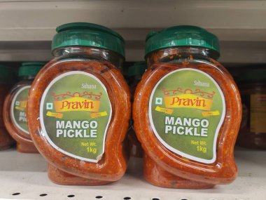 Pune, Maharashtra, Hindistan - 13 Ocak 2025; çok çeşitli gıda ürünleriyle dolu hareketli bir market koridoru. Süpermarketteki raflar satılmak üzere renkli paketlerle dolu..