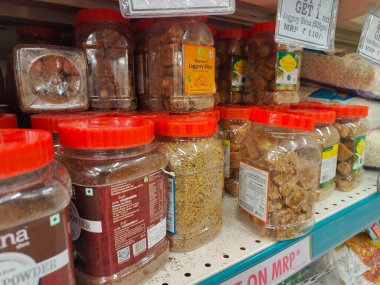 Pune, Maharashtra, Hindistan - 13 Ocak 2025; çok çeşitli gıda ürünleriyle dolu hareketli bir market koridoru. Süpermarketteki raflar satılmak üzere renkli paketlerle dolu..