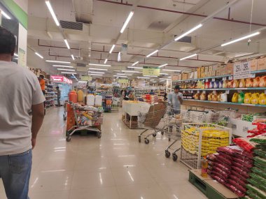Pune, Maharashtra, Hindistan - 13 Ocak 2025; çok çeşitli gıda ürünleriyle dolu hareketli bir market koridoru. Süpermarketteki raflar satılmak üzere renkli paketlerle dolu..