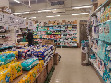 Pune, Maharashtra, Hindistan - 13 Ocak 2025; çok çeşitli gıda ürünleriyle dolu hareketli bir market koridoru. Süpermarketteki raflar satılmak üzere renkli paketlerle dolu..