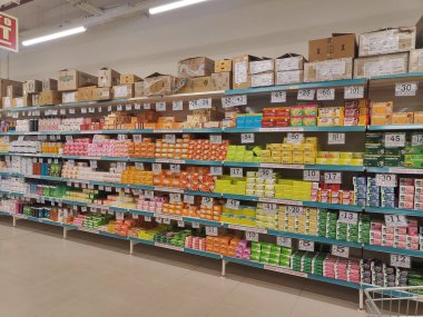 Pune, Maharashtra, Hindistan - 13 Ocak 2025; çok çeşitli gıda ürünleriyle dolu hareketli bir market koridoru. Süpermarketteki raflar satılmak üzere renkli paketlerle dolu..