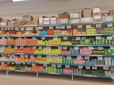 Pune, Maharashtra, Hindistan - 13 Ocak 2025; çok çeşitli gıda ürünleriyle dolu hareketli bir market koridoru. Süpermarketteki raflar satılmak üzere renkli paketlerle dolu..