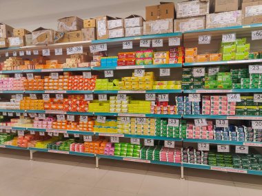 Pune, Maharashtra, Hindistan - 13 Ocak 2025; çok çeşitli gıda ürünleriyle dolu hareketli bir market koridoru. Süpermarketteki raflar satılmak üzere renkli paketlerle dolu..