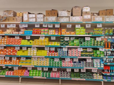 Pune, Maharashtra, Hindistan - 13 Ocak 2025; çok çeşitli gıda ürünleriyle dolu hareketli bir market koridoru. Süpermarketteki raflar satılmak üzere renkli paketlerle dolu..