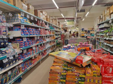 Pune, Maharashtra, Hindistan - 13 Ocak 2025; çok çeşitli gıda ürünleriyle dolu hareketli bir market koridoru. Süpermarketteki raflar satılmak üzere renkli paketlerle dolu..