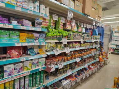 Pune, Maharashtra, Hindistan - 13 Ocak 2025; çok çeşitli gıda ürünleriyle dolu hareketli bir market koridoru. Süpermarketteki raflar satılmak üzere renkli paketlerle dolu..