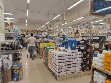 Pune, Maharashtra, Hindistan - 13 Ocak 2025; çok çeşitli gıda ürünleriyle dolu hareketli bir market koridoru. Süpermarketteki raflar satılmak üzere renkli paketlerle dolu..