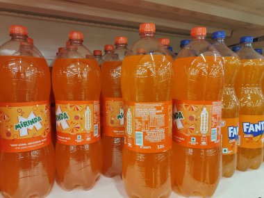 Pune, Maharashtra, Hindistan - 13 Ocak 2025; çok çeşitli gıda ürünleriyle dolu hareketli bir market koridoru. Süpermarketteki raflar satılmak üzere renkli paketlerle dolu..