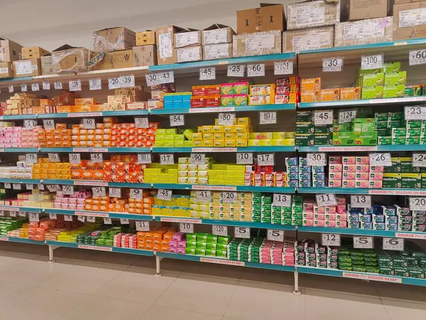 Pune, Maharashtra, Hindistan - 13 Ocak 2025; çok çeşitli gıda ürünleriyle dolu hareketli bir market koridoru. Süpermarketteki raflar satılmak üzere renkli paketlerle dolu..