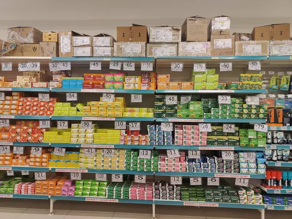 Pune, Maharashtra, Hindistan - 13 Ocak 2025; çok çeşitli gıda ürünleriyle dolu hareketli bir market koridoru. Süpermarketteki raflar satılmak üzere renkli paketlerle dolu..