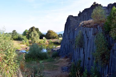 Rocks beautifully arranged by nature, covered with grass and trees.