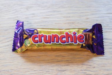 Cadburys çikolatalı abur cuburu masaya koyar.