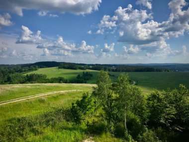 Dağların huzurlu manzarası, arka planda toprak bir yol.
