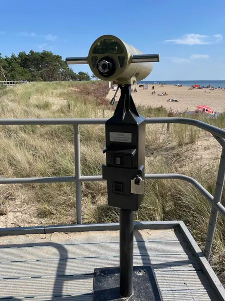 Sahilde bir bakış açısı, ön planda bir teleskop..