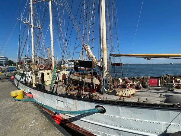 Limanda duran büyük, eski bir yelkenli gemi, görünür yelkenler ve ekipmanlar..