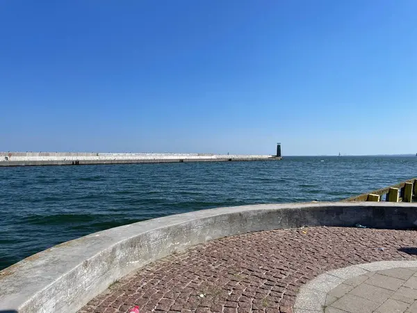 Liman girişinin manzarası, kaldırım taşlarıyla kaplı bir dalgakıran..