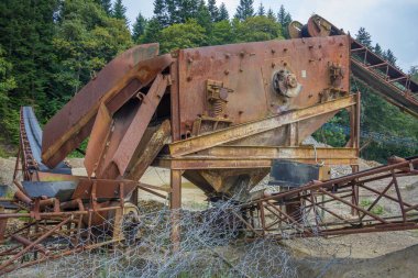 Paslı ve bozuk bir makine tarlada oturur. Makine eski ve terk edilmiş.