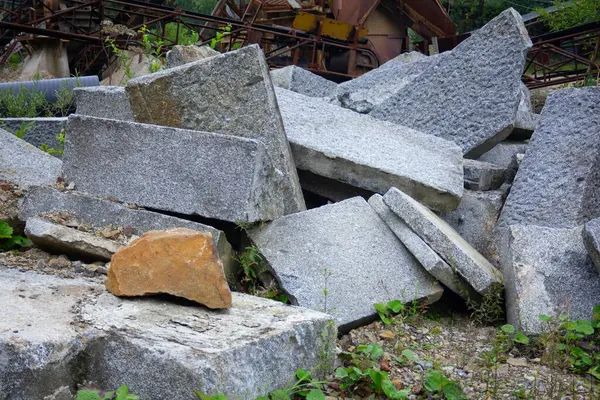 Ortasında büyük bir kaya olan bir moloz yığını. Kaya kahverengidir ve moloz gridir.