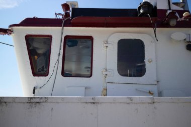 Kırmızı üst ve beyaz tabanlı bir tekne. Üst taraf açık, alt taraf kapalı.