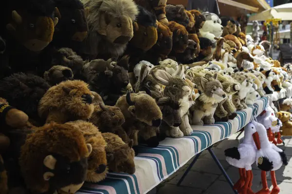 Doldurulmuş hayvanlarla dolu bir masa. Çeşitli kahverengi ve beyazlar da dahil. Sahne canlı ve renkli, bir neşe ve sıcaklıkla dolu.