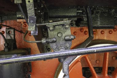 Kırmızı ve siyah dizaynlı bir tren motorunun içi. Motor eski ve paslı.