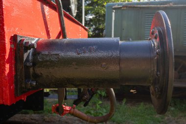 Üzerinde siyah-beyaz numarası olan siyah-kırmızı bir tren motoru. Motor çimenli bir alana park edilmiş.