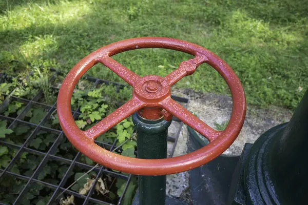 Kırmızı ve siyah renkli bir vana yeşil bir boruya yerleştirilir. Kapakçık borunun üzerine yerleştirilmiş. Sıvı ve gazların akışını kontrol etmek için çok önemli bir bileşen.