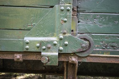 Yeşil metal parçası paslanmış ve bir sürü deliği var. Çok kullanılmışa benziyor ve tamire ihtiyacı var.