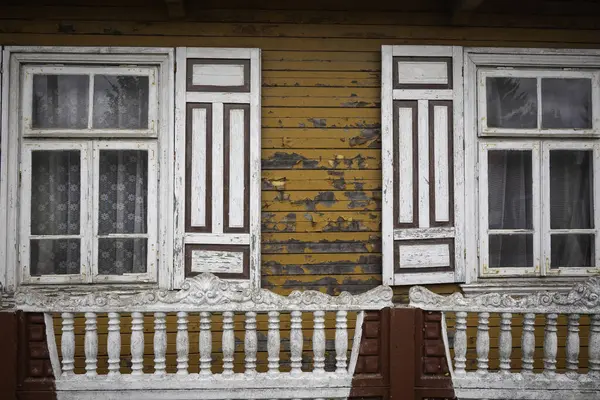 Evin bir sürü penceresi ve bir balkonu var. Pencereler beyaz ve balkon kırmızı.