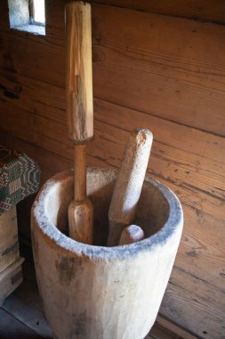 Tahta bir havan ve tokmak ahşap bir kasede oturur. Kase üç tahta çubukla dolu. Çubuklar farklı boyutlarda ve birbirlerine dokunacak şekilde dizilmişler.