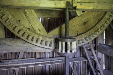 İçinde büyük ahşap bir tekerlek olan ahşap bir yapı. Tekerlek ahşap parmaklıklarla çevrilidir ve ortasında metal bir parçası vardır. Eski ve eski bir yapı gibi görünüyor, bir tarih duygusu var.